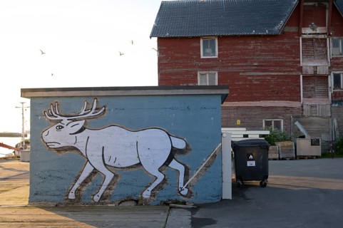 Mural depicting a reindeer at the harbor. Vardö street art phenomenon created by the festival