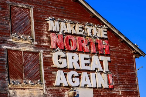 Red fishing building with the inscription Make the North great again at Vardö harbour, Vardø,