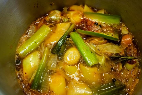 A vegetable stock is cooked, various vegetables are boiled with spices and herbs in water for a