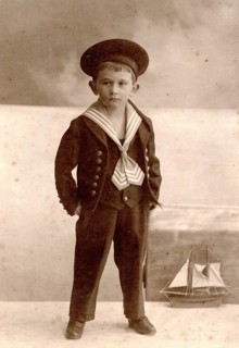 Historical cabinet card, boy in sailor suit against maritime studio backdrop with sailing ship,