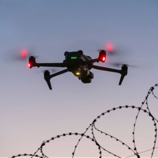 Symbolic picture, drone flying just over barbed wire, airport, threat, espionage