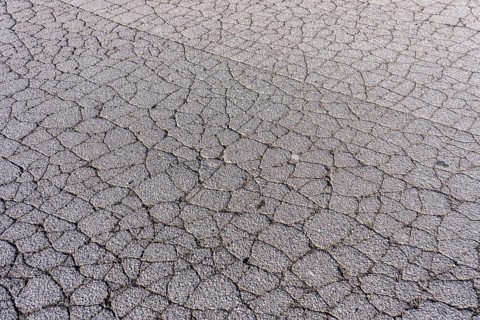 Asphalt surface, floor, with many small cracks, roadway, parking lot