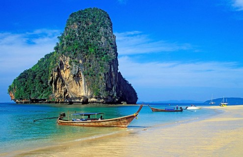 Rocks in the sea and longtail boats on Pranang Cave beach, two years in front of the tsunami,