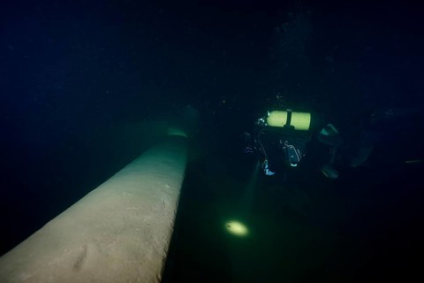 Diver examines a lediwreck, wreck of a lediship, ledi ship, cargo ship for mass freight, bulk