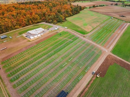 Solar frame on a field near an autumn forest and industrial site, Energiewende, construction of PV