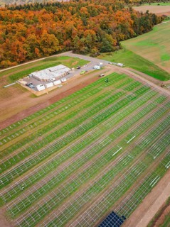 Rural plant for solar installation with adjacent forest in autumn colors, energy revolution,