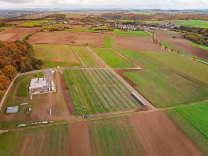Panoramic view of fields with a solar park and an adjacent small village, Energiewende,