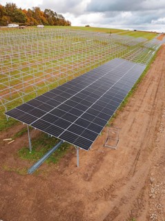 Solar system construction on a wide, cloudy field landscape, energy revolution, construction of PV