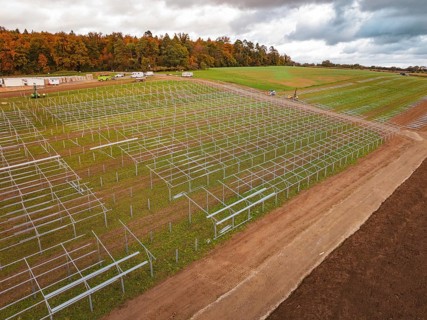 Racks for solar panels spread over an extensive landscape under cloudy sky, Energiewende,