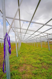 A long metal frame in a meadow running parallel to an autumn sky, Energiewende, construction of PV