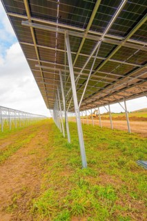 Side view of a large metal structure for solar panels in open countryside, energy revolution,