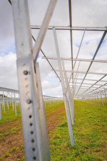 Empty metal structures for solar systems on a green field under cloudy sky, Energiewende,