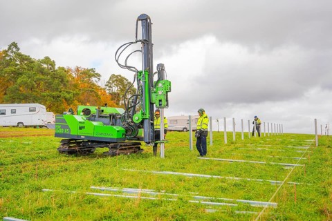 A drilling rig is operated by workers on a green field in autumn, Energiewende, construction of PV