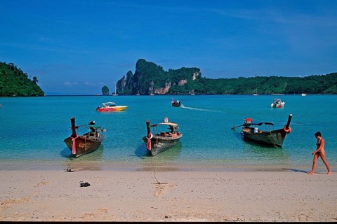 Young woman, longtail boats on the beach of Ko Phi Phi Don, two years in front of the tsunami,