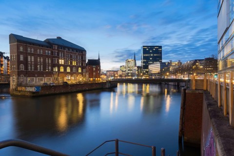 View from Oberbaum Bridge of the Zollkanal and Teerhof at blue hour with reflections in the water