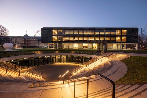The state parliament of Stuttgart glows impressively in the evening. The architecture is