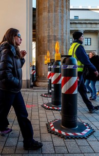 Passers-by at the security barrier made of massive bollards at the Brandenburg Gate passage,