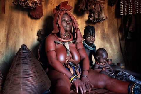 Himba woman sitting with baby, Himba perfume, scented smoke from burning plants, Himba village,