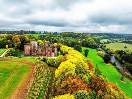 Autumn Colours over ruins of Goodrich Castle and River Wye from a drone, Goodrich, Herefordshire,