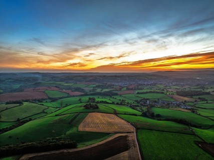 Sunset of Devon Farms and Fields over Berry Pomeroy from a drone, Totnes, England, United Kingdom