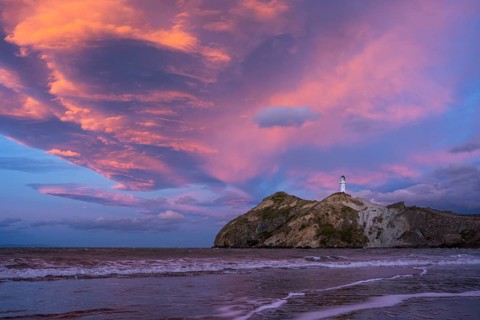 Castlepoint Beach, ocean and lighthouse on a rock, evening, sunset, dramatic sky. Castlepoint,