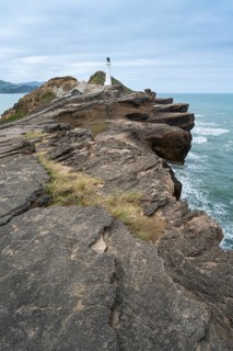 Castlepoint lighthouse on a rock, ocean. Castlepoint, Wairarapa Coast, Wellington Region, North