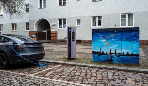 Electric charging station next to a blue-painted distribution box on public roads, Berlin, Germany