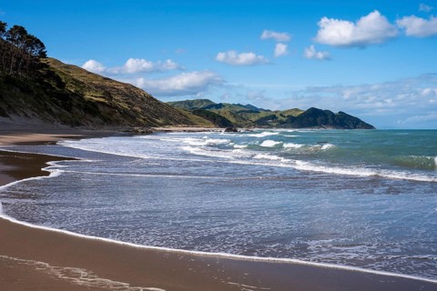 Castlepoint Beach, ocean, sandy beach, surf, mountains. Castlepoint, Wairarapa Coast, Wellington