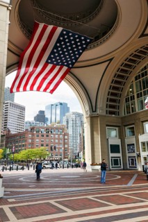American flag fluttering, distinctive archway, Boston Harbor Hotel, Rowes Wharf, passers-by,