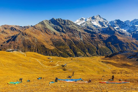 Paragliders prepare their start, summit of the Corne de Sorebois, with the backdrop of the Valais