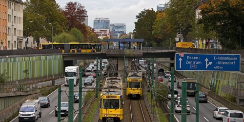 Lots of traffic on the A 40 motorway on four lanes and two subways on two lanes and a bus on the