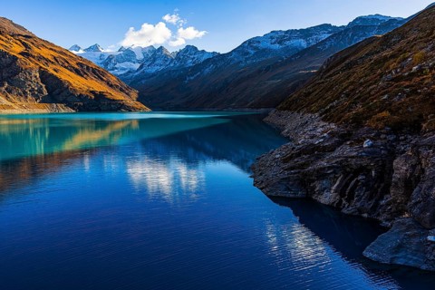 The turquoise Lac de Moiry reservoir, behind the peaks of the Grand Cornier, Tete Blanche and