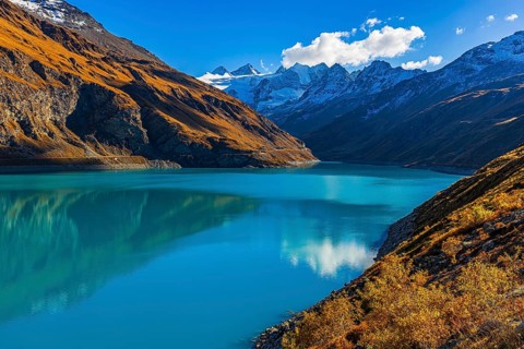 The Lac de Moiry reservoir, with the snow-capped peaks of the Grand Cornier, Tete Blanche and