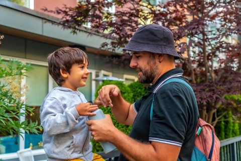 Father and son sharing a joyful bonding moment in vancouver, as dad opens a water bottle for his