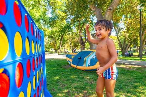 Happy child celebrating winning a game of giant four in a row in a park in kamloops, british