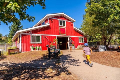 Mother with open arms welcoming her son, joyfully running toward her at the entrance of a large red