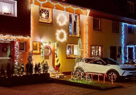 Christmassy kitschy illuminated façade of a row house in Gelsenkirchen-Ückendorf in the evening,