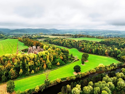 Autumn Colours over ruins of Goodrich Castle and River Wye from a drone, Goodrich, Herefordshire,
