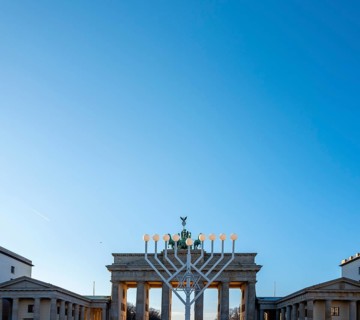 Large Hanukkah chandelier at the Brandenburg Gate in daylight, sign of lively Jewish life, symbolic
