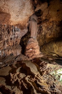 Stalactites and stalagmites, rock formations in a stalactite cave with water basin, Grotta del