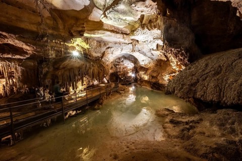 Stalactites and stalagmites, small underground lake, rock formations in a stalactite cave, Grotta