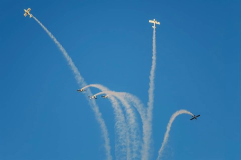 Stunt aerobatic planes performing stunts in blue sky with smoke trail. Concept of teamwork,