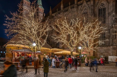 Famous Nuremberg bratwurst house decorated at Christmas time, Sebaldus Church in the back,