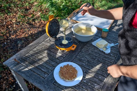 Preparation of waffles with a waffle iron on an outdoor garden table, Othenstorf,
