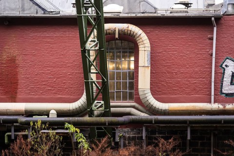 District heating pipeline in front of old industrial buildings on the banks of the Wupper,