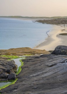 Granite rocks in the evening light and turquoise blue sea at Gurteen Beach, Roundstone, County