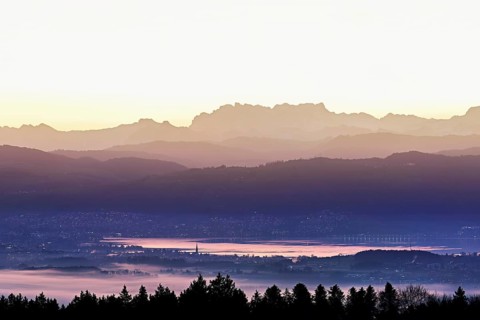 View from Horben of Lake Zug with the town of Cham and Zug, behind it the snow-capped mountains