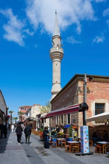 Street view with minaret and cafes under a clear blue sky, Yali Mosque, Tavil Ahmet Aga Mosque,