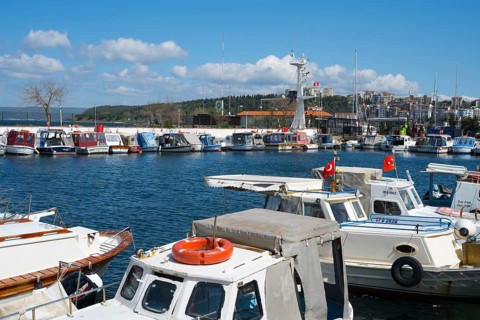 A busy harbor full of boats with flying flags under blue skies, Çanakkale, Canakkale, Marmara