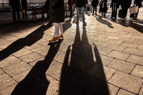 Passers-by on a sidewalk on Grunerstraße, near Alexander Platz, bus stop, in Berlin, shade, low